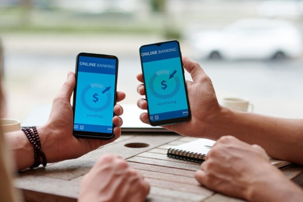 Send Payments Anytime, Anywhere Two People Holding Smartphones Displaying an Online Banking Interface, Indicating a Money Transfer in Progress